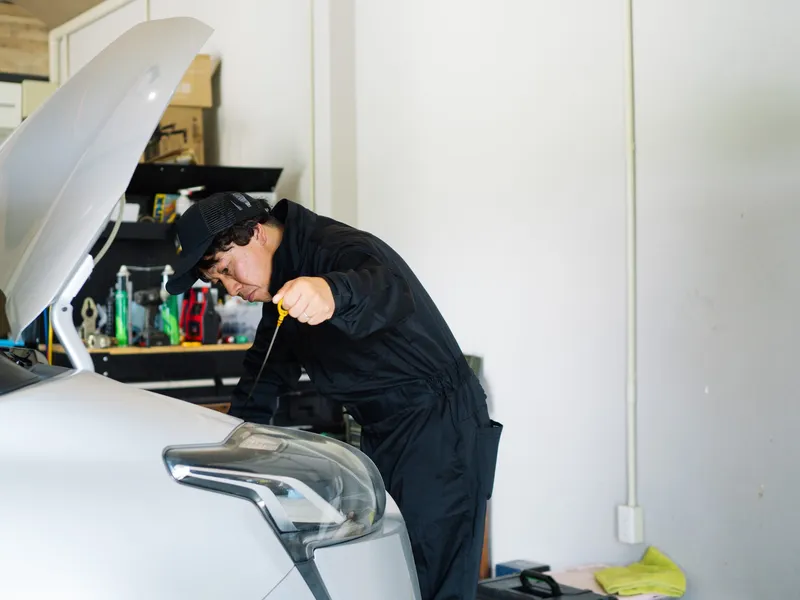 ボンネットを開けて修理する職人