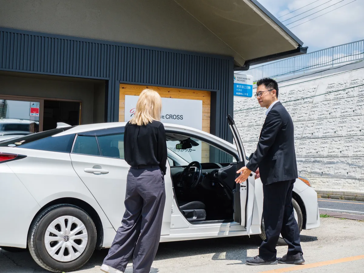 お客様をお車にご案内するスタッフ